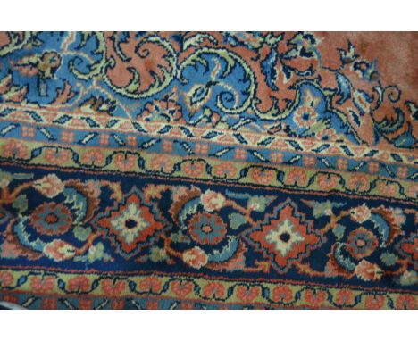 Persian pattern carpet, central floral medallion on a red ground within guards, broad floor border, 385cm x 278cm.