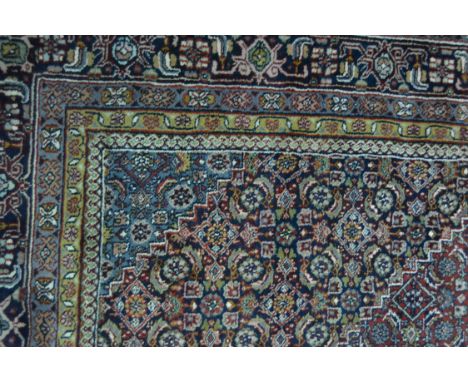 Persian pattern carpet, with a central lozenge medallion, red ground, profusely decorated with stylised patterns, within guar