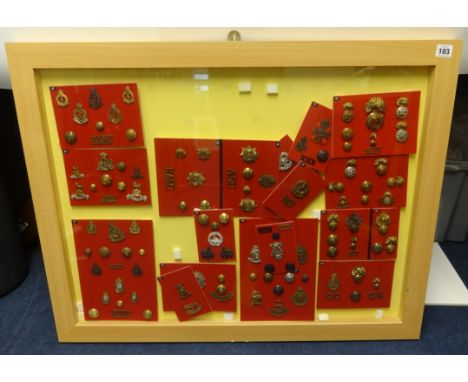 A framed collection of Military badges and buttons of various Regiments including Royal Welsh Fusiliers and Royal Army Ordnan