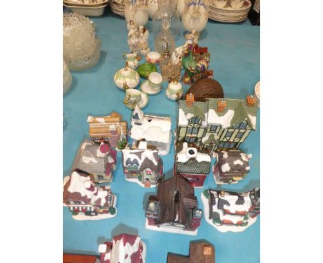 A collection of ceramic ornaments, bisque vases, pottery cottages etc