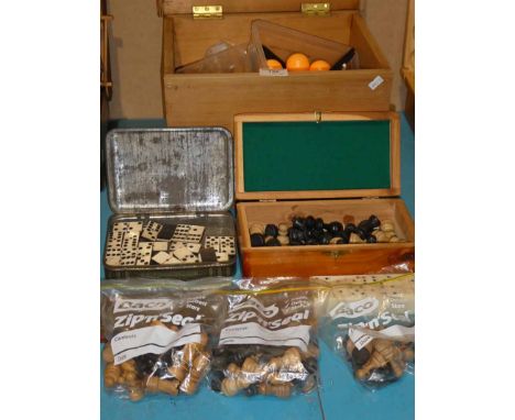 A small group of games including: Dominoes, a cribbage board, ping-pong, chess set and three part sets, and a flower press.