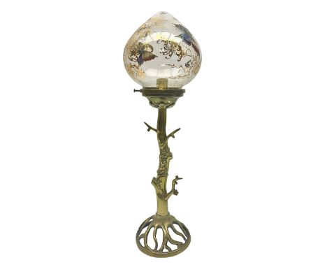 Art Nouveau style table lamp, modeled as a tree with roots upon the circular base, with a glass shade with gilt decoration an