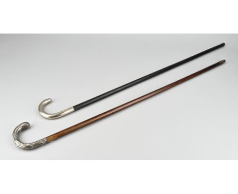 Two walking sticks with silver handle, half round, one smooth model and one model decorated with medallion and acanthus leave