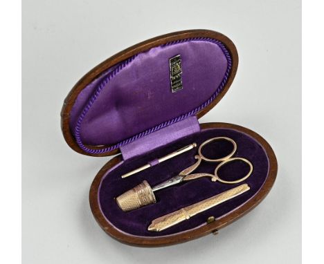 Yellow gold sewing kit, 585/000, in an oval mahogany wooden case. Gold needle, needle case, thimble and scissors with gold ha