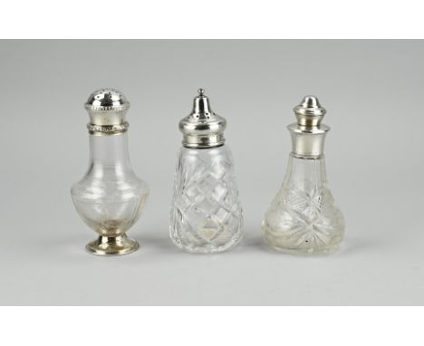 Three pieces of crystal with silver. A flacon with etching, set on a silver round base and with a silver round sprinkle cap d
