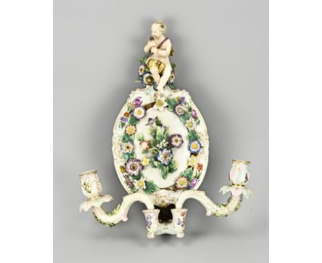 18th century porcelain wall candlestick with decorated flowers and putti. Damage to flowers. Marked W + *. Size: 37 cm. Presu
