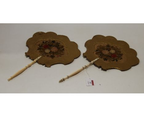 A pair of Regency hand screens, each having a floral embroidered panel within silk surround on turned ivory handles, length 3