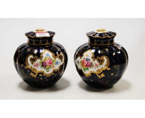 A pair of Royal Crown Derby pot pourri jars and covers, each of squat melon form, on a cobalt blue ground, the central panel 