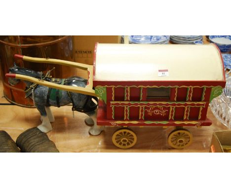 A painted model of a gypsy caravan with ceramic shire horse