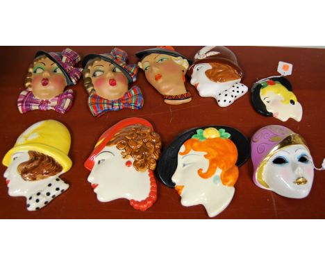 A pair of Art Deco style painted plaster wall masks, each in the form of a lady in tartan hat and bow, 17cm; together with va