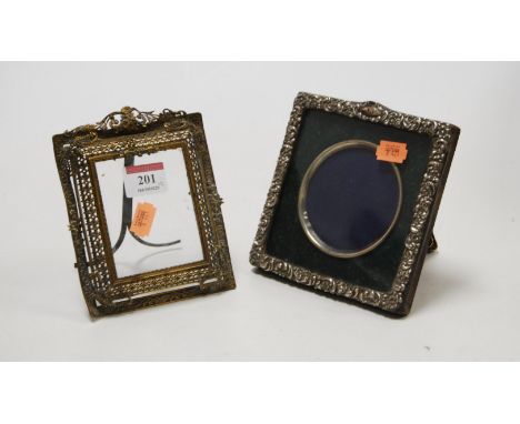 An Edwardian silver clad easel photograph frame, having typical floral and C-scroll decoration, 14 x 14cm; together with a br