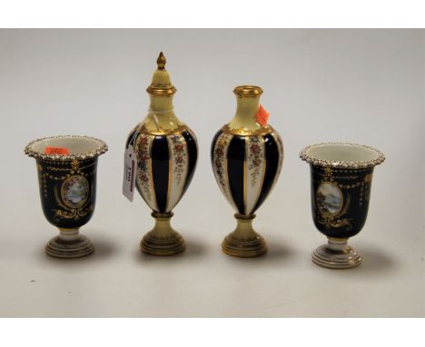 A pair of Royal Crown Derby urn shaped vases, each on a cobalt blue ground, the central panel painted with a mountain landsca