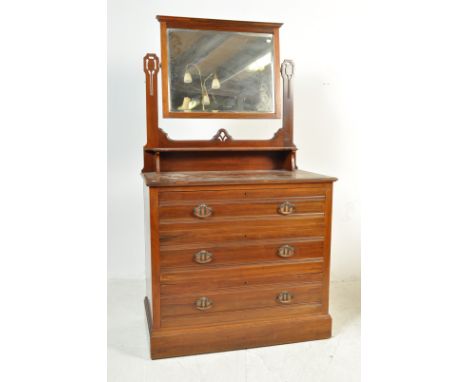 An Edwardian walnut Art Nouveau dressing chest of drawers. Raised on a plinth base with short and deep drawers with upright s