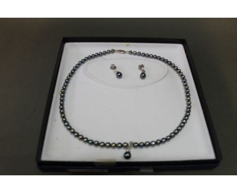 A black pearl necklace set with diamonds marked 750 with pair of matching earrings  