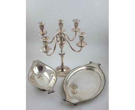 A mid 20th century silverplated dish of elliptical form together with a similar oval tray and a 5 light candleabra.