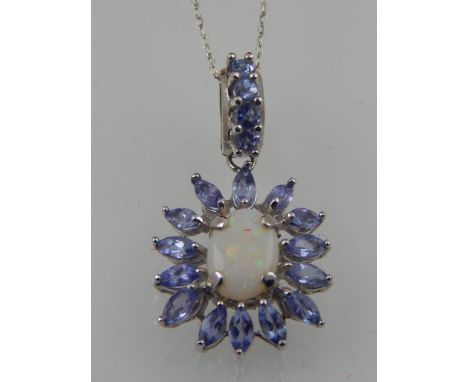 A 9 carat white gold, tanzanite, and opal cluster drop pendant, suspended on a 9 carat white gold chain. 