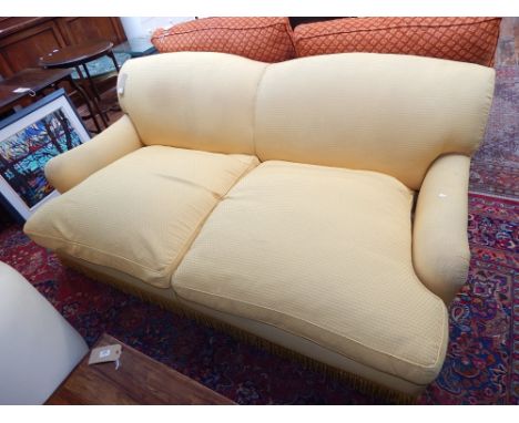 A large 20th century yellow fabric upholstered sofa, with two feather upholstered cushions and fringe base, W 200cm