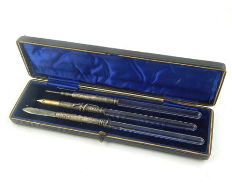 A late Victorian silver mounted three piece desk set of pen, pencil and lancet, with hexagonal cut glass stems, two with entw