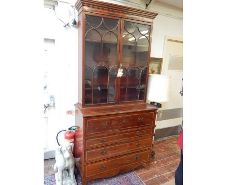 A George III mahogany secretaire bookcase, the dentil cornice above astragal doors enclosing adjustable shelves, the base wit