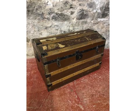 A wooden bound, dome top travel trunk 