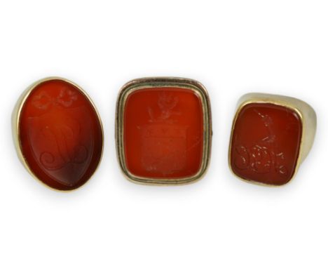 A Victorian 9ct and carnelian set intaglio ring, carved with a crest size L and two other similar yellow metal and carnelian 