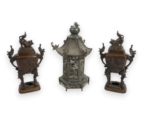 A pair of Japanese bronze koros and covers, late Meiji period, with lion-dog finials, stylised dragon handles and panels of b