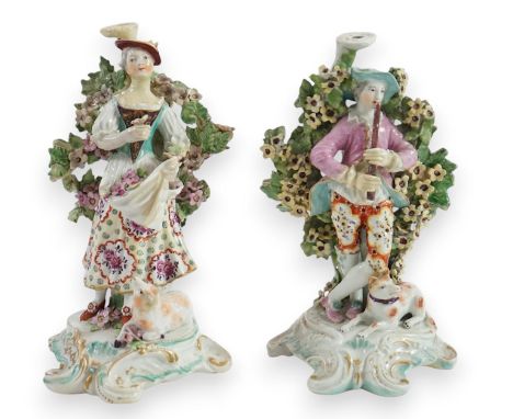 A pair of Derby candlestick groups of a shepherd and shepherdess, c.1775, both lacking upper sconces, she holding a basket of