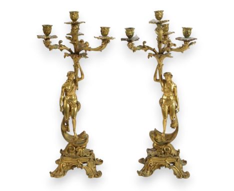 A pair of 19th century French ormolu five light ‘Venus’ figural candelabra with foliate scroll branches and figural stems dep