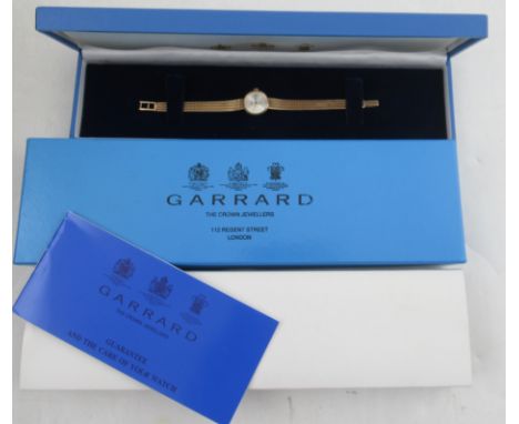 A 9ct gold hallmarked Garrard ladies wrist watch, with its original box, outer box, paper work etc with an inscription to the