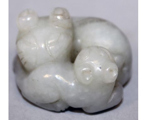 A SMALL CHINESE JADE GROUP OF TWO CATS, the predominantly white stone with darker inclusions, 1.2in wide & 0.75in high.