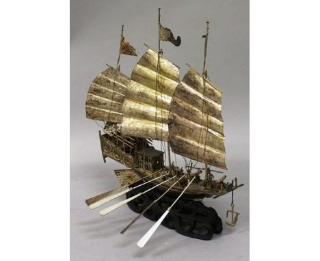 A 19TH/20TH CENTURY CHINESE SECTIONAL SILVER-METAL MODEL OF A JUNK, together with a fixed wood stand, the silver-metal itself