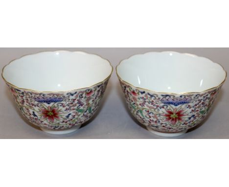 A PAIR OF CHINESE FAMILLE ROSE PORCELAIN BOWLS, each decorated with bats above scroll-stemmed lotus, each base with a Qianlon