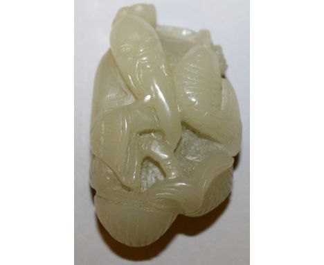 A CHINESE CELADON JADE PENDANT OF AN IMMORTAL, holding a carp, 2.25in high.