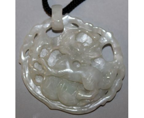 A CHINESE CELADON JADE PENDANT, carved to one side with a kylin, 2in wide x 1.75in high.