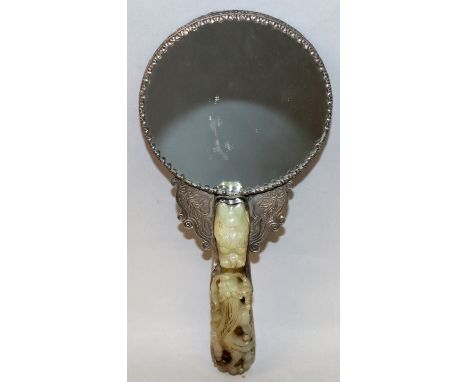 AN EARLY 20TH CENTURY CHINESE JADE HANDLED SILVER-METAL HAND MIRROR, the rear of the mirror with embossed decoration of a dra