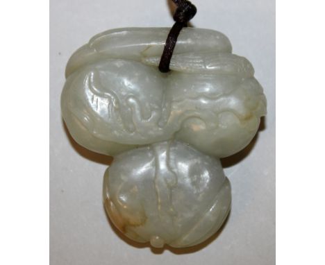 A CHINESE JADE PENDANT, in the form of a cluster of three peaches, the stone of a celadon grey-green hue, 2.1in high x 2in wi