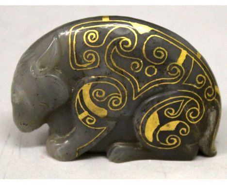 A CHINESE HAN STYLE GILT DECORATED JADE CARVING OF A MYTHICAL ANIMAL, the gilding of archaic design, the stone of dark celado