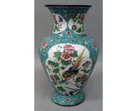 AN EARLY 20TH CENTURY CHINESE CANTON ENAMEL VASE, the sides decorated with shaped panels of birds and foliage reserved on a t