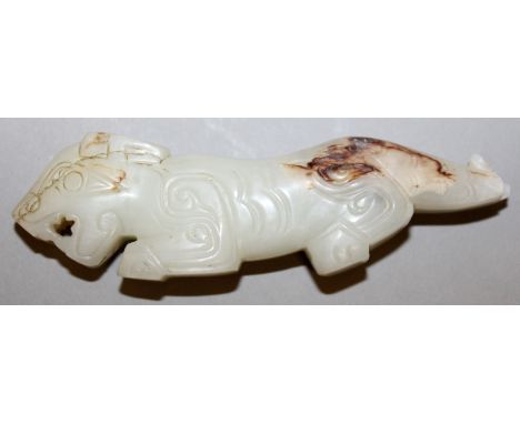 AN EARLY 20TH CENTURY CHINESE JADE CARVING OF A MYTHICAL ANIMAL, the pale stone with russet inclusions, 3.5in long.