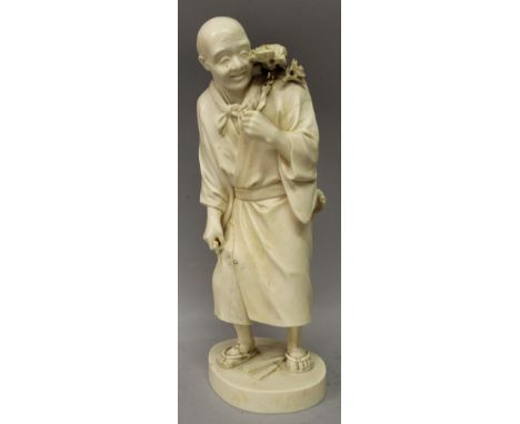 A LARGE GOOD QUALITY JAPANESE MEIJI PERIOD TOKYO SCHOOL IVORY OKIMONO OF A STANDING MAN, holding an axe in one hand and a bra