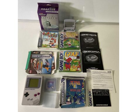 A Nintendo Game Boy and magnifying screen together with games MARIO GOLF, TETRIS and SUPER MARIO ADVANCE for Game Boy Advance