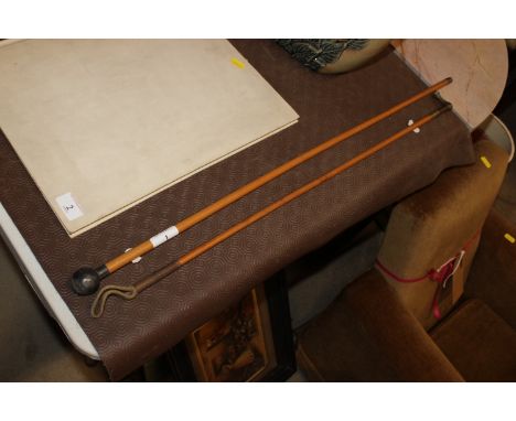 A silver topped swagger stick and a brass handled riding crop