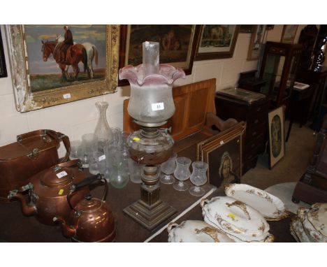 A brass based oil lamp with cut glass font and shade 