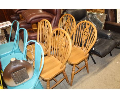 A set of four beech stick and wheelback dining chairs 
