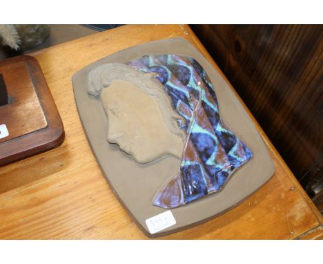 A Royal Copenhagen Aluminia part glazed stoneware plaque depicting a girl with scarf designed by Johannes Hedegaard, impresse