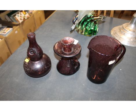An amethyst coloured bubble glass jug with similar chamber stick and vase 