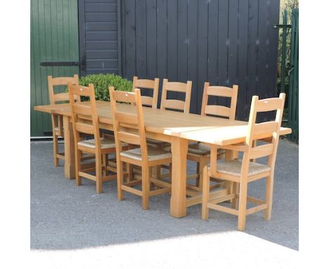 A light oak dining table with two leaves, 190 x 90cm, together with a set of eight rush seated dining chairs, 281 x 91cm full