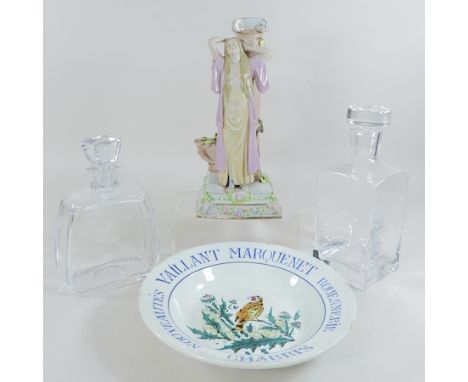 A continental porcelain figural candlestick, 30cm tall, together with two glass decanters and a French advertising dish