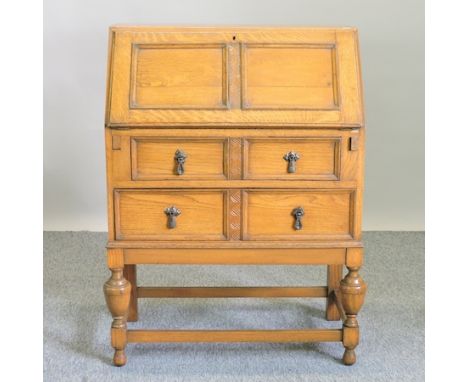 A 1920's light oak bureau, 74cm, together with an oak box and two jardiniere stands (4)