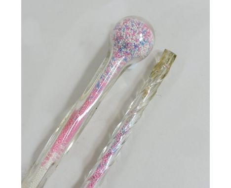 A glass walking stick, together with another